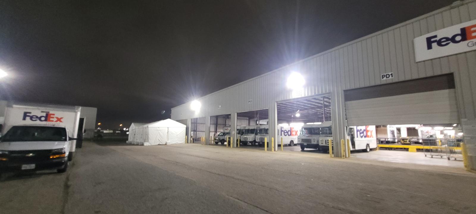 Professional exterior LED lighting installation at FedEx distribution facility at night showing bright commercial lighting