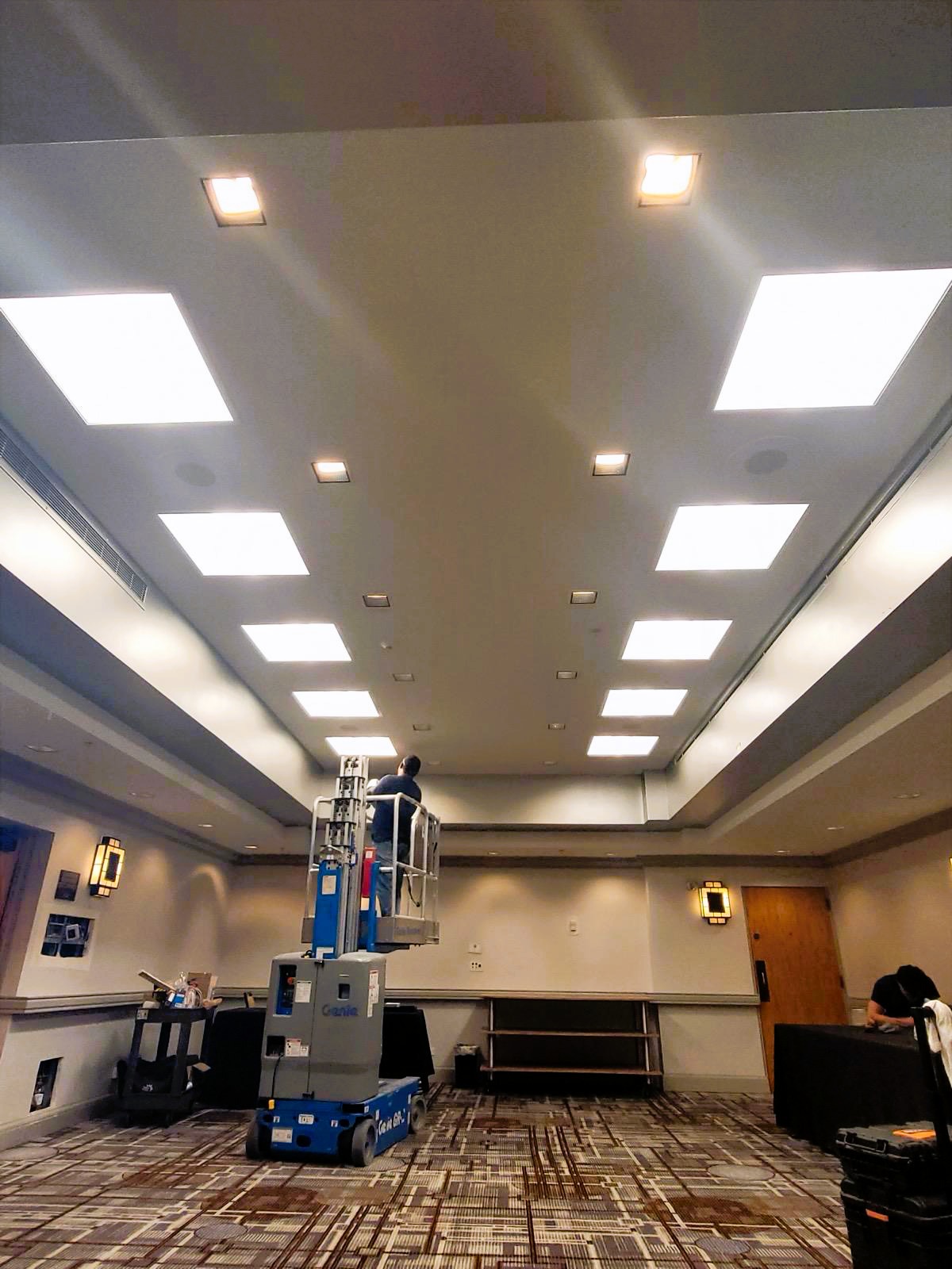 Professional LED ceiling panel installation in commercial conference room with integrated lighting system and smart controls